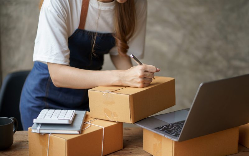 Close-up of an online business owner woman check customer lists to properly pack and ship to customers.